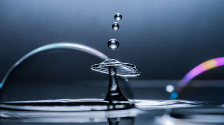 A macro shot of a water drop collision amongst some bubbles.