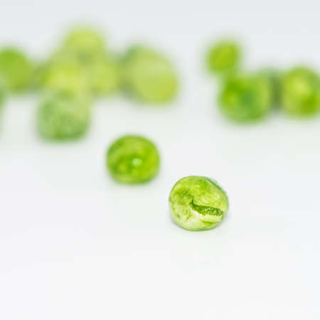 A macro shot of a group of frozen peas against a white background.の写真素材