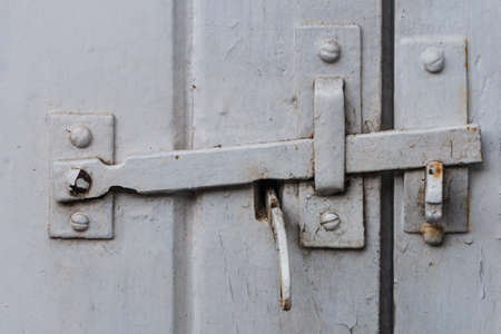 A shot of a metallic door latch on a wooden door.の写真素材