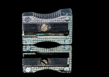 A macro shot of a pencil sharpener shot against a black background and showing a reflection.の写真素材