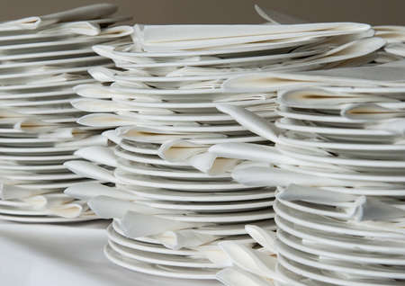 A shot of some stacked white plates and serviettes.の写真素材