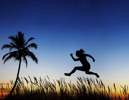  An athlete jumping through the air against a sunset view の写真素材