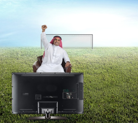 arabian man watching TV and reacting - front view の写真素材