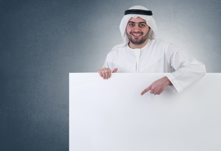 arabian business man pointing at a blank white sign の写真素材