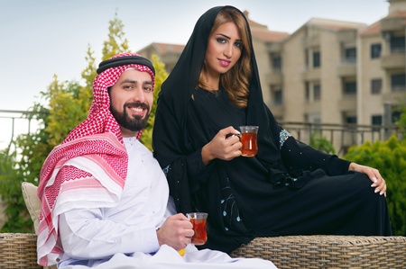 Arabian couple relaxing in the garden and drinking tea