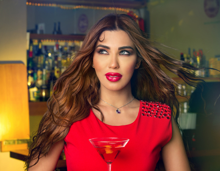 Sexy young woman with a glass of martini in a pub  の写真素材