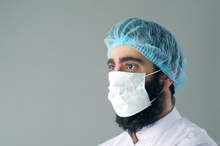 Male surgeon posing against a grey backgroundの写真素材