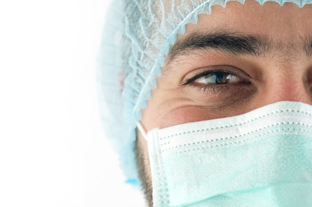 young male doctor in medical mask, close-up, isolated on whiteの写真素材