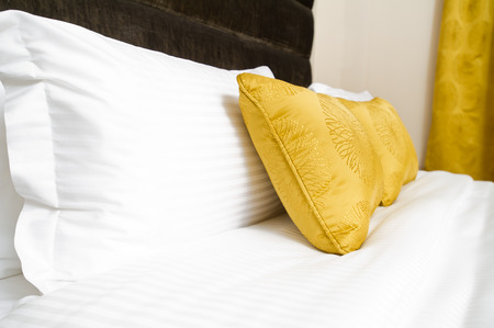 Cushions , Yellow pillows on bedの写真素材