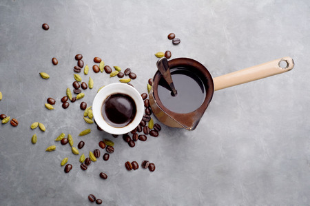 Turkish Coffee with coffee beans and Cardamom scattered on a vintage background