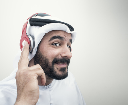 Stylish Arabian man in headphones, Arabian guy listening to music?の写真素材