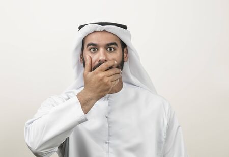 Portrait of a shocked Arabian man covering his mouth , Arabian guy shockedの写真素材