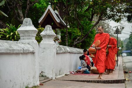 Luang Pra bang, Laos : 13 DEC 2014 Unidentified monks walk to collect alms and offerings.This procession is held every early morning in Luang prabang.のeditorial素材