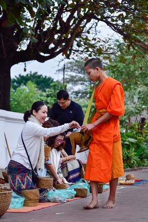 Luang Pra bang, Laos : 13 DEC 2014 Unidentified monks walk to collect alms and offerings.This procession is held every early morning in Luang prabang.のeditorial素材