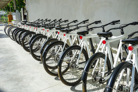 A rental bicycles stand in a row on a parking.の写真素材