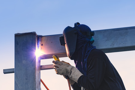Worker welding parts of stell construction