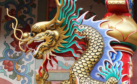 colorful dragon statue on the roof of chinese templeの写真素材