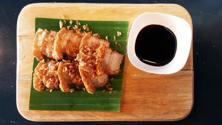 Chinese Crispy Pork with sweet black sauce recipe serving on banana leaf and wooden plateの写真素材
