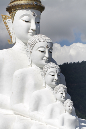Five white buddha statues sitting well alignment in front of blue sky and decorating wonderful attractive mirror, one of the most interesting landmark in north of Thailandの写真素材