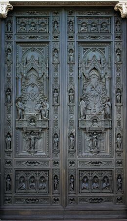 Ancient drak brown metal door window, Beautiful church entry to the house of christian god surrounding with white art statue decoration, resident decoration backgrounds wallpaperの写真素材