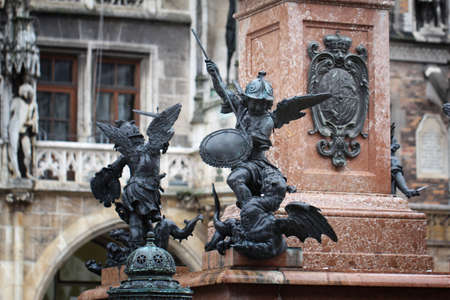 Close-up ancient statue of Putto killing devil at the Marian column's pedestal Marienplatz, Munich, Germany, travel destination backgroundsの写真素材