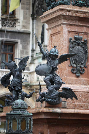 Close-up ancient statue of Putto killing devil at the Marian column's pedestal Marienplatz, Munich, Germany, travel destination backgroundsの写真素材
