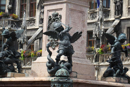 Close-up ancient statue of Putto killing devil at the Marian column's pedestal Marienplatz, Munich, Germany, travel destination backgroundsの写真素材