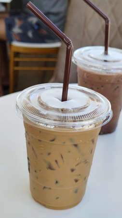 Freshness iced coffee cafe latte in disposable take away cup with brown Straw, advsertising backgroundsの写真素材
