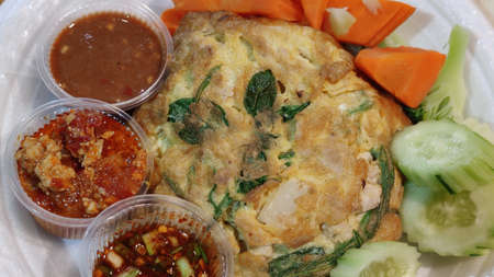 Organic herb Omelette With spinach, chives And Oregano Sprinkled leaf serving with sliced cucumber...