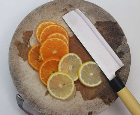 High angle view of organic freshness slide lemon and orange on wooden plate with sharp knife at home kitchen, fruit advserting backgroundsの写真素材