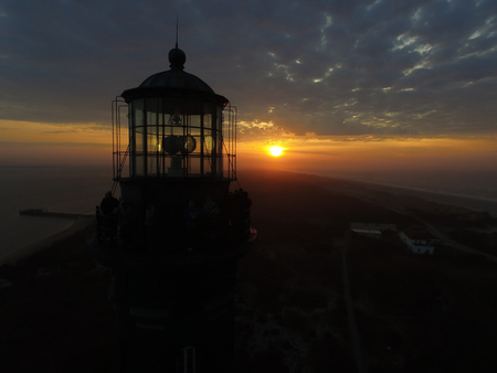 Drone View of a Sunrise at the beach next to a lighthouseの写真素材