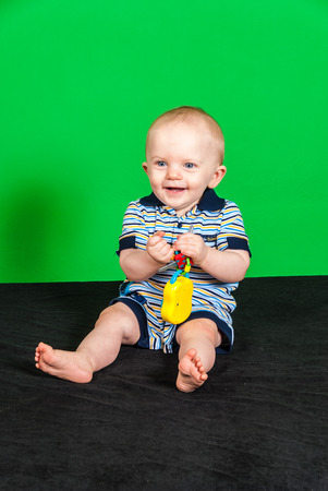 Happy 10 Month Old Baby Boy on Green Screen Playing with Toyの写真素材