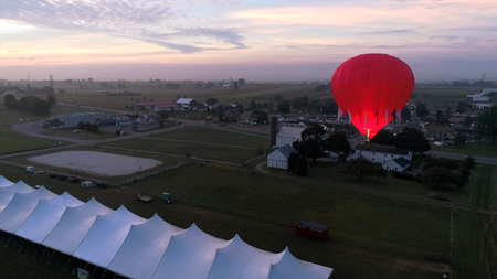 Aerial View of Sunrise with Hot air Balloons Taking Off with Glow as Seen by a Droneの写真素材