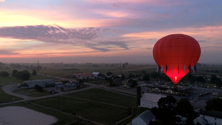 Aerial View of Sunrise with Hot air Balloons Taking Off with Glow as Seen by a Droneの写真素材