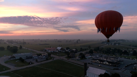 Aerial View of Sunrise with Hot air Balloons Taking Off with Glow as Seen by a Droneの写真素材