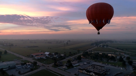 Aerial View of Sunrise with Hot air Balloons Taking Off with Glow as Seen by a Droneの写真素材