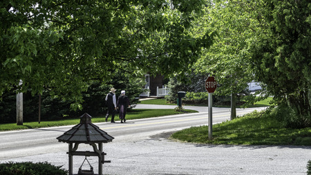 Amish Couple Walking on a Residential Road on a Summer Dayの写真素材