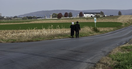 Amish Couple Walking on a Residential Road on a Summer Dayの写真素材