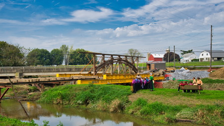 Dismantling a Burr Arch Covered Bridge With Amish Children Watching as Seen on a Spring Dayの写真素材