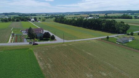 Aerial View of Amish Farm Land and a Horse and Buggy Going Down the Roadの写真素材