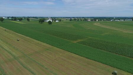Aerial View of an Amish Farmer Harvesting His Crop with 4 Horses and Modern Equipmentの写真素材