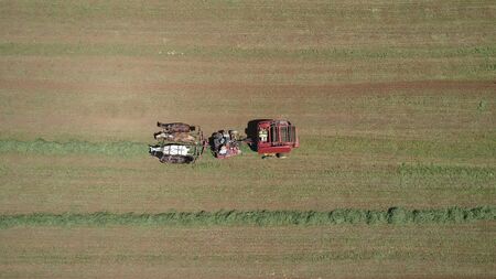 Aerial View of an Amish Farmer Harvesting His Crop with 4 Horses and Modern Equipmentの写真素材