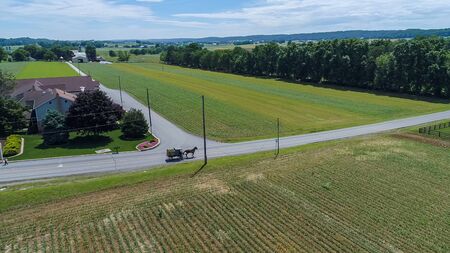 Aerial View of Amish Farm Land and a Horse and Buggy Going Down the Roadの写真素材