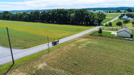Aerial View of Amish Farm Land and a Horse and Buggy Going Down the Roadの写真素材