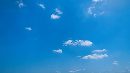 White Fluffy Clouds Floating in the Bright Blue Skies on a Summer Dayの写真素材