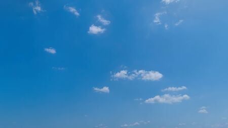 White Fluffy Clouds Floating in the Bright Blue Skies on a Summer Dayの写真素材
