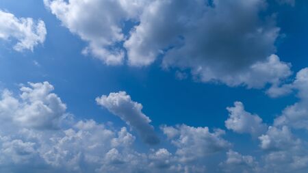 White and Dark Fluffy Clouds Floating in the Bright Blue Skies on a Summer Dayの写真素材