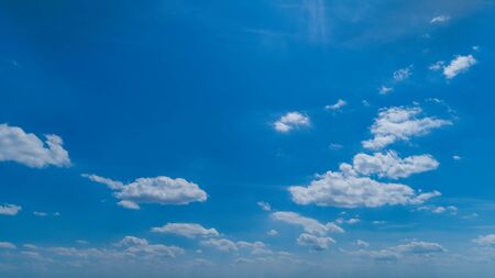 White Fluffy Clouds Floating in the Bright Blue Skies on a Summer Dayの写真素材