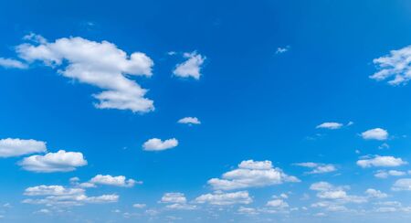 White Fluffy Clouds Floating in the Bright Blue Skies on a Summer Dayの写真素材