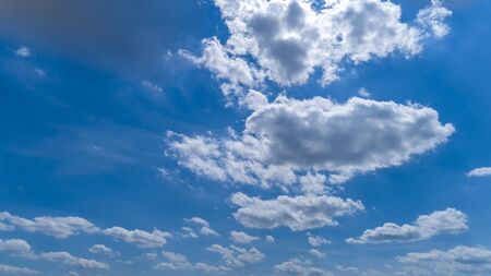 White and Dark Fluffy Clouds Floating in the Bright Blue Skies on a Summer Dayの写真素材